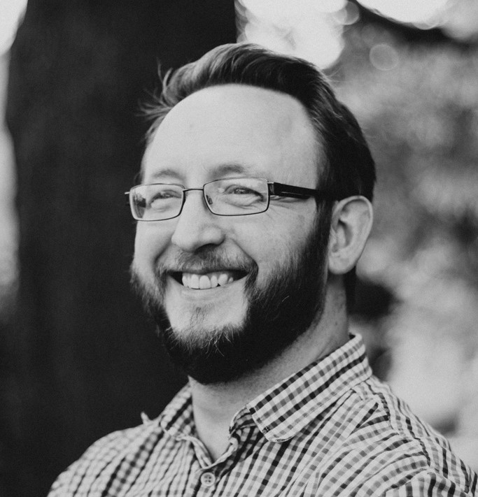 Photograph of University of Bristol lecturer Professor Jon Ives. Black and white image, smiling with glasses.